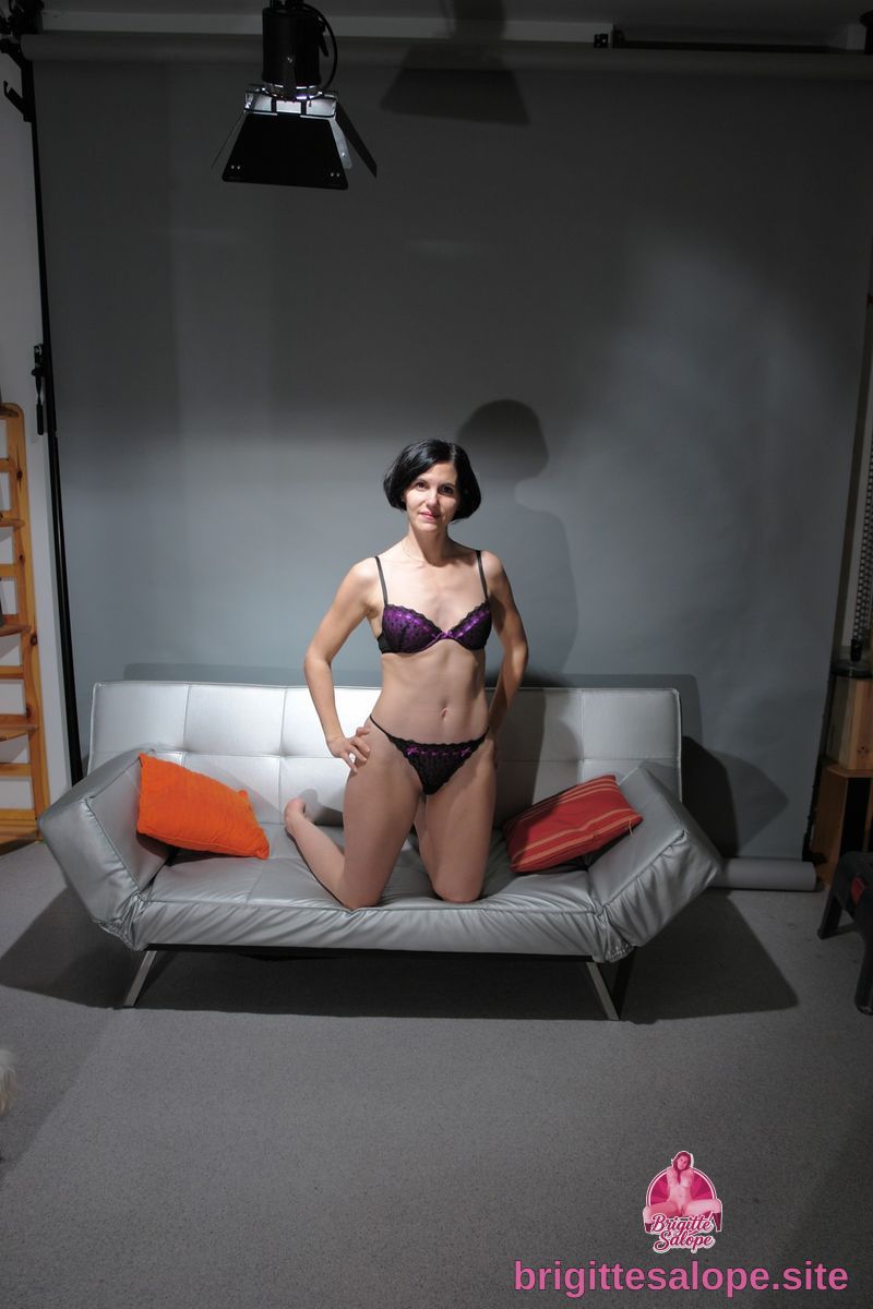 Femme en lingerie noire sur un canapé gris — Brigitte la Salope
